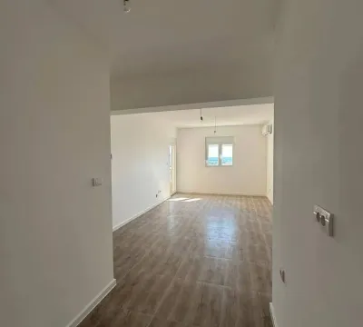 View from the hallway into an unfurnished room with wooden flooring. - image 6