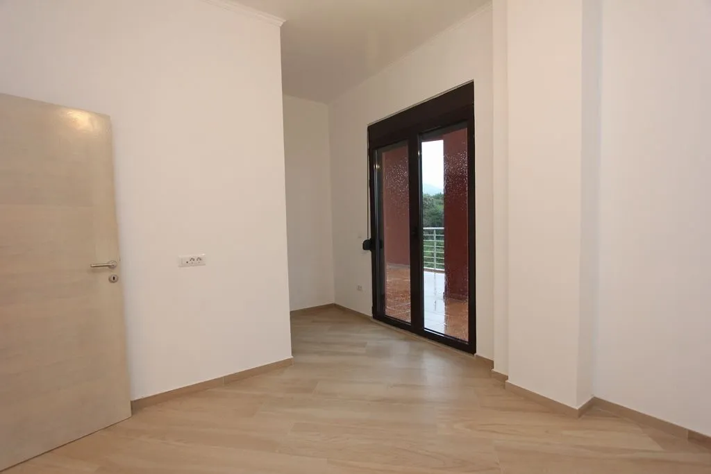 Svijetla prazna soba sa izlazom na balkon.