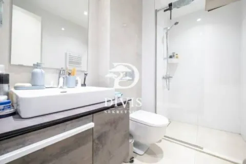 Modern bathroom with a washbasin, walk-in shower, and toilet. - image 6