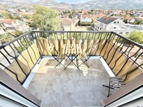 Namješten balkon sa garniturom za sjedenje i pogledom na naselje i planine. - image 7