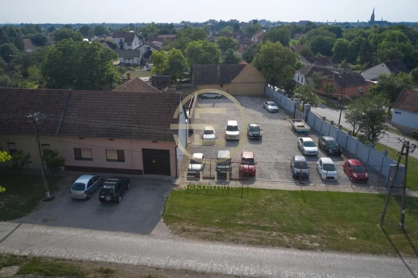 Pogled iz vazduha na dvorište sa parking prostorom i okolnim objektima.