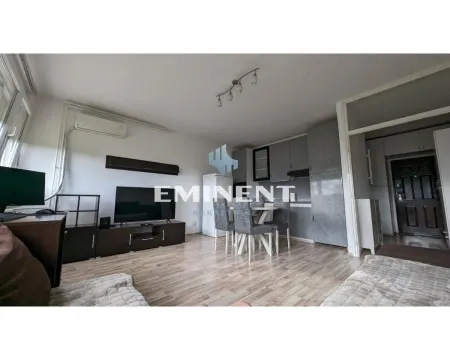 Living room with a dining area and part of the kitchen in the background. - image 2