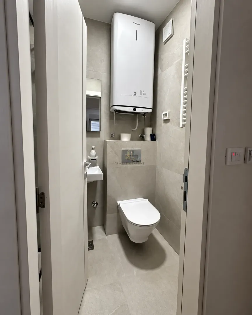 View of a modern bathroom with a toilet and water heater.