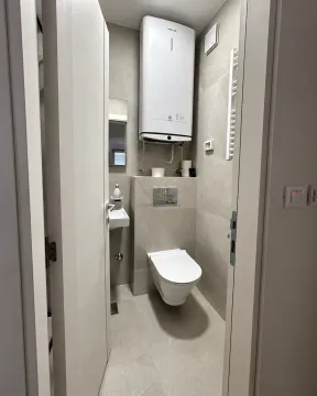 View of a modern bathroom with a toilet and water heater. - image 5