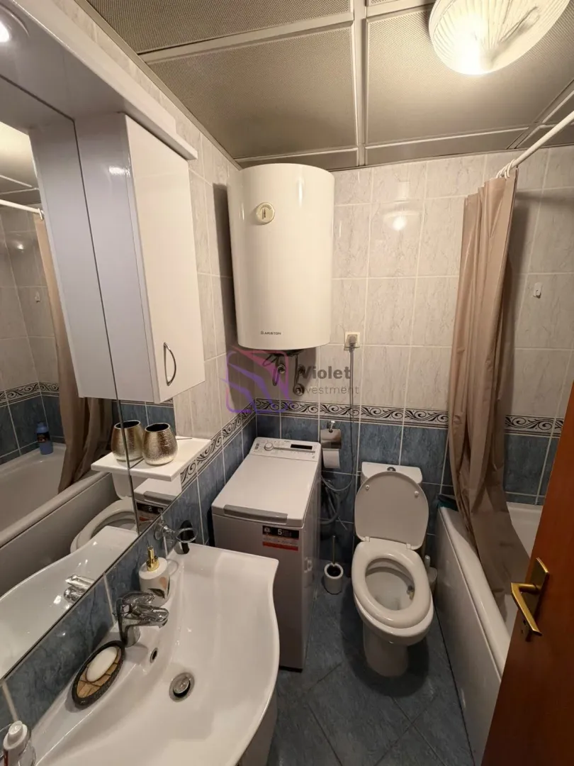 Bathroom equipped with a washbasin, toilet, bathtub, and washing machine.