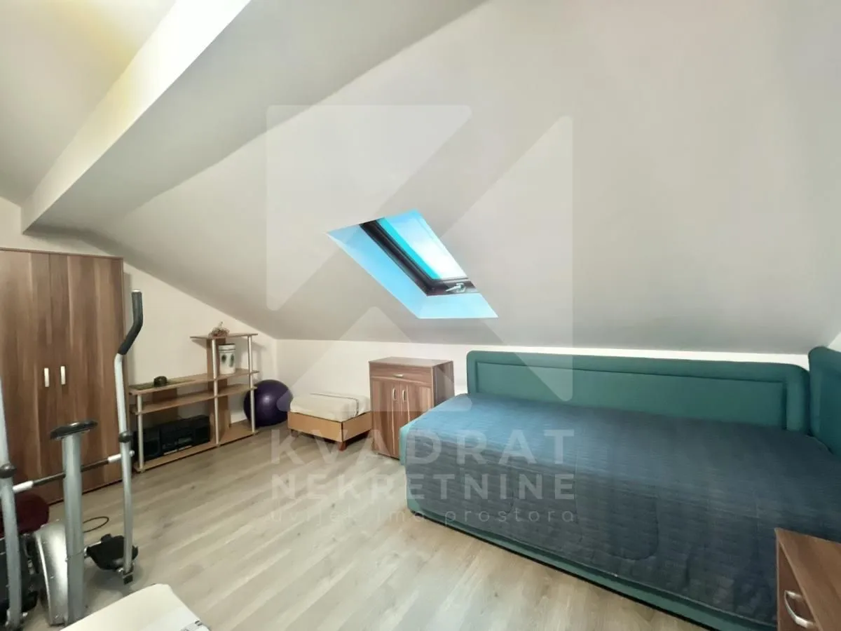 Attic bedroom with a bed and a skylight.