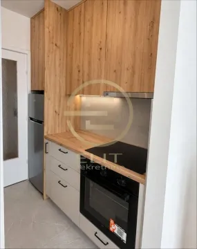 Manja kuhinja sa drvenim elementima, ugradnom rernom i frižiderom. - image 12
