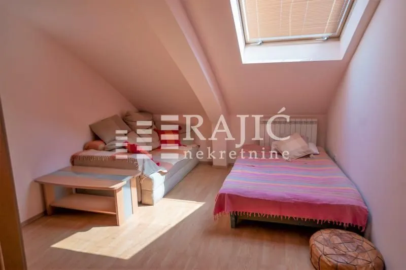 Attic bedroom with a bed and a skylight.