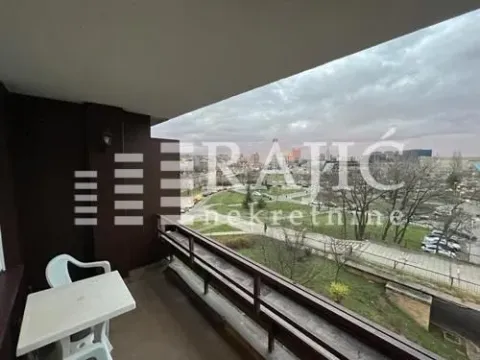 Natkrivena terasa sa stolom i pogledom na grad. - image 2