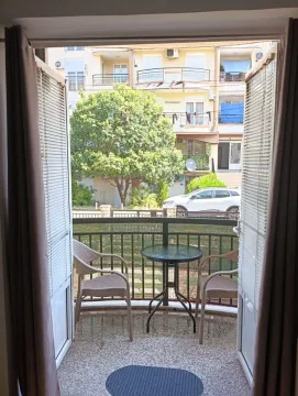 Manji balkon sa garniturom za sjedenje i pogledom na zgrade i zelenilo. - image 4