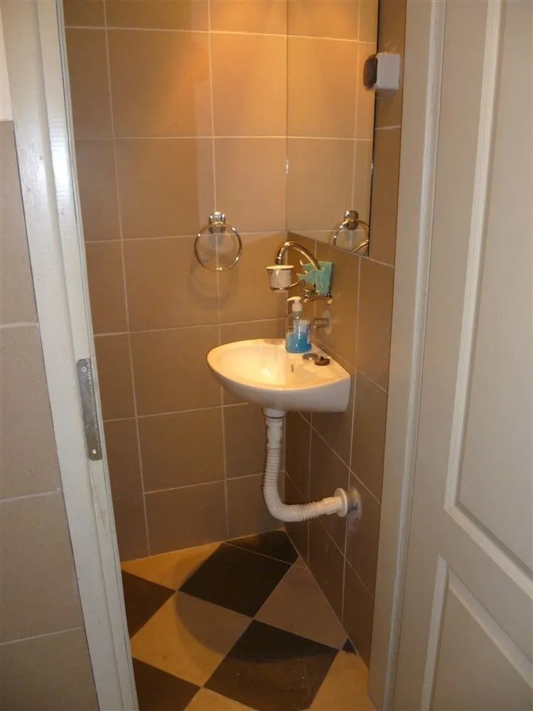 A small restroom featuring a sink and mirror.