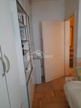 Smaller bedroom with a built-in wardrobe and open shelves. - image 10