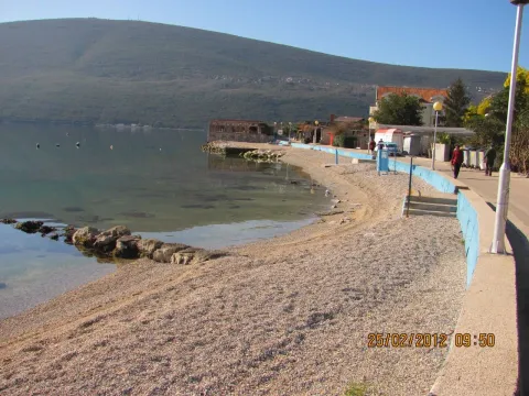 Pogled na šetalište, plažu i obalu mora sa planinom u pozadini. - image 2