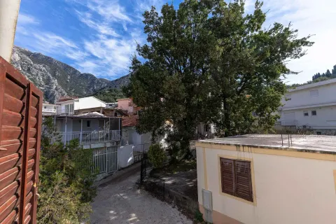 Pogled izbliza na dvorište i okolne kuće sa drvećem. - image 14