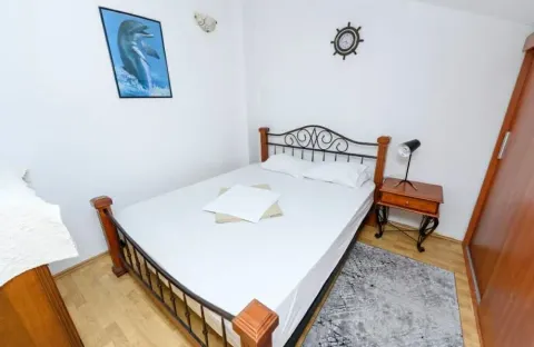 Furnished bedroom with a double bed, nightstand, and wardrobe. - image 14