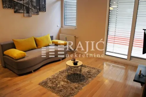 Living room with a sofa and hardwood flooring. - image 4