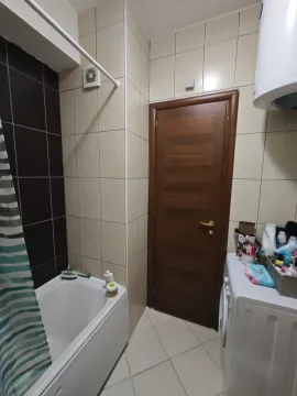 Manje kupatilo sa kadom, drvenim vratima i veš mašinom. - image 8