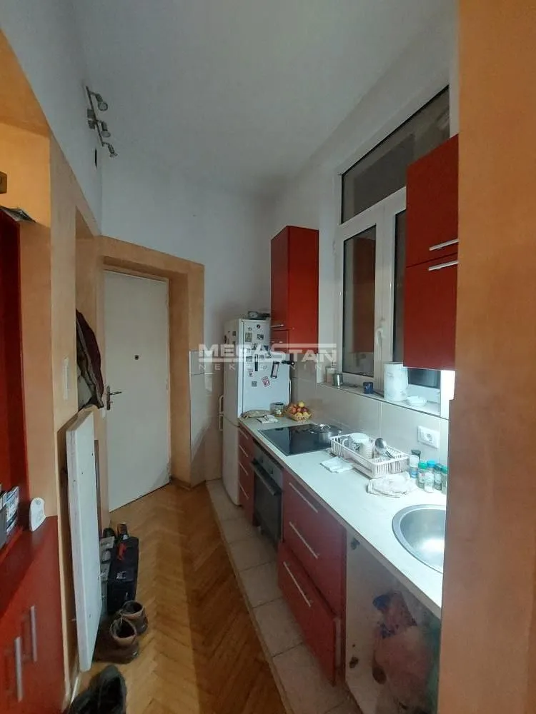 Small kitchen with red cabinets and built-in appliances.