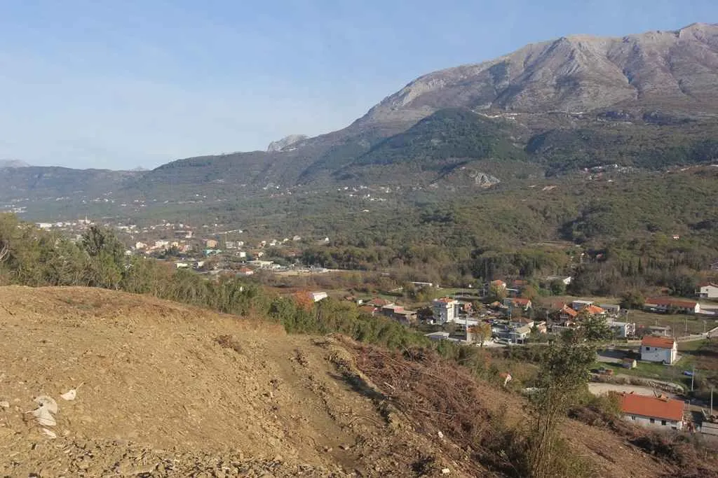 Pogled sa građevinskog placa na dolinu i planine u pozadini.