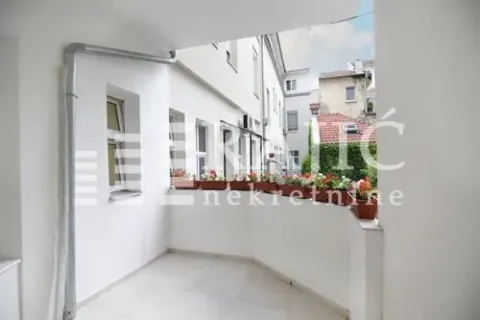 Spacious white terrace with flower boxes and a view of buildings. - image 9