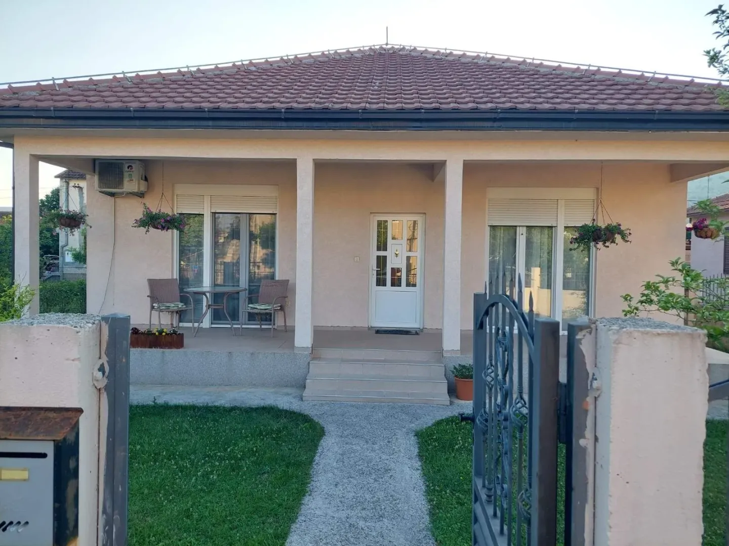 Exterior view of a family house with a yard and entrance.