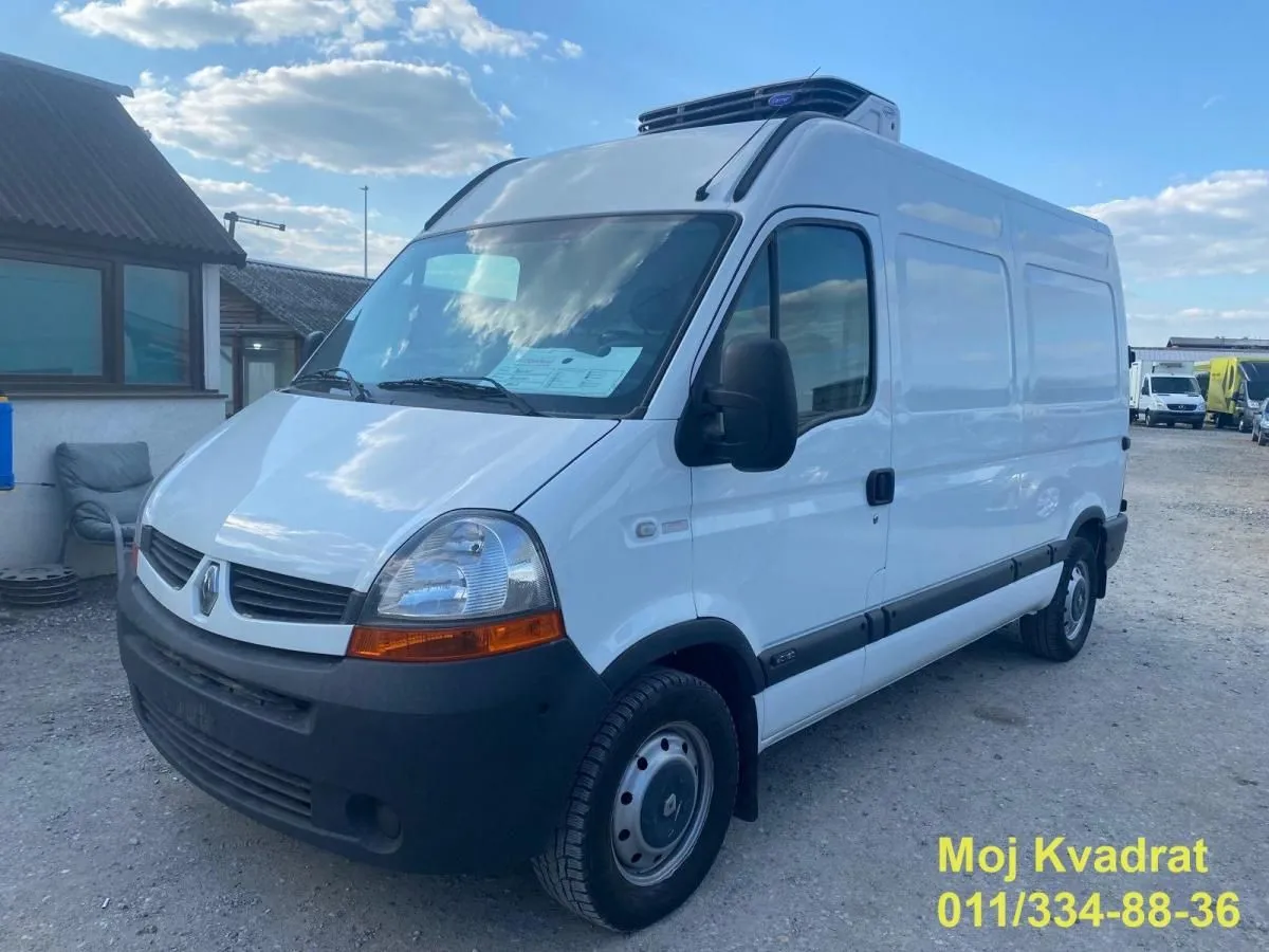 Beli kombi parkiran na otvorenom prostoru.