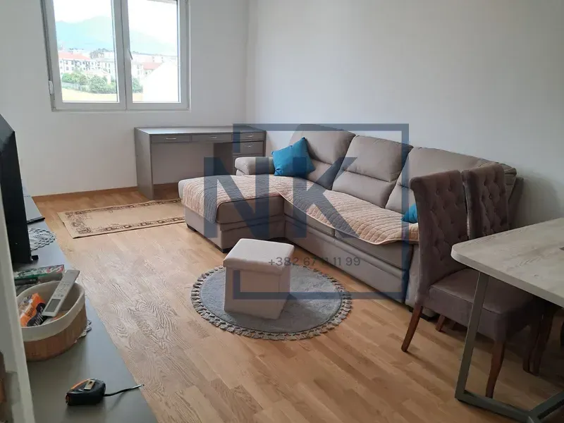 Living room with a sofa, a desk, and a dining area.