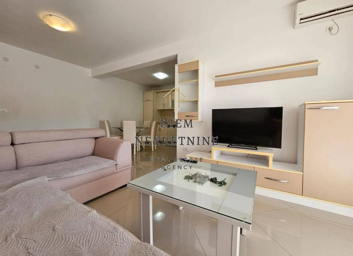 Spacious living room with a sofa and TV unit.