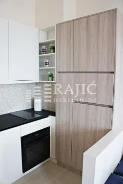 Modern kitchen with white and wood-finish cabinetry. - image 10