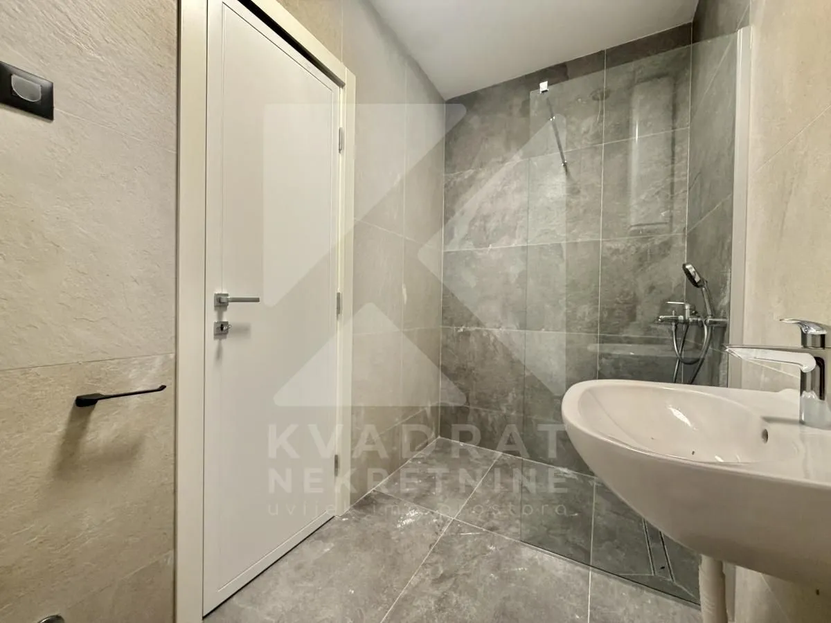 Modernly equipped bathroom with a walk-in shower and a washbasin.