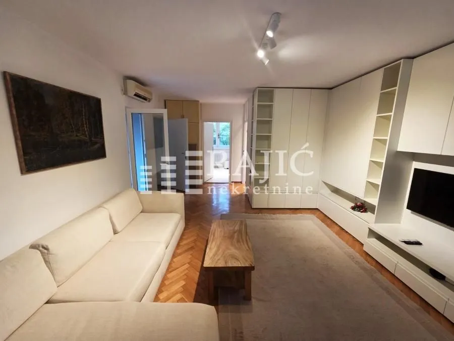Living room with a sofa, wooden coffee table, and built-in closets.