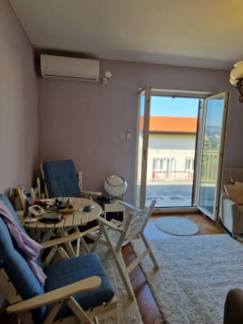 Dnevna soba sa prostorom za sjedenje i izlazom na terasu.