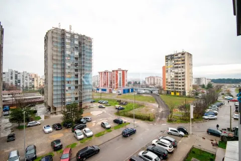 View from the apartment overlooking surrounding residential buildings and parking. - image 9