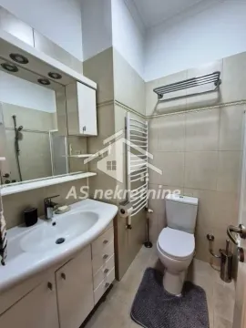 Bathroom equipped with a vanity sink, toilet, and towel radiator. - image 16