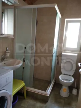 Smaller bathroom with a shower cabin, sink, and toilet. - image 7