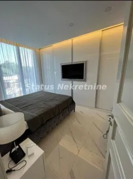 Modern bedroom with a large double bed, built-in wardrobe, and television. - image 11