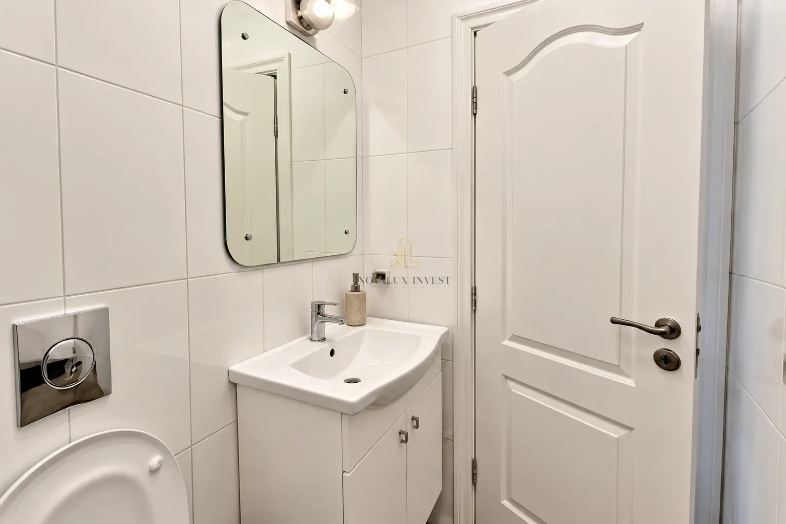 View of a modernly equipped bathroom with a washbasin and a mirror.