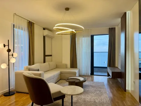 Modern and bright living room with a sofa, coffee table, and sea view. - image 2