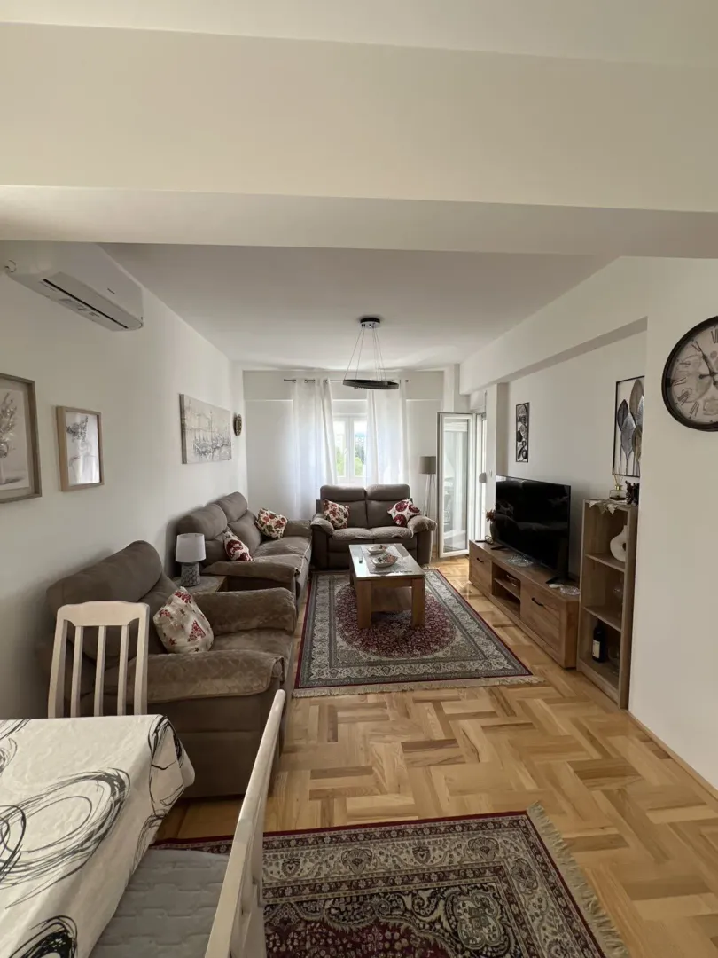 Bright and tidy living room with a seating set and a TV.