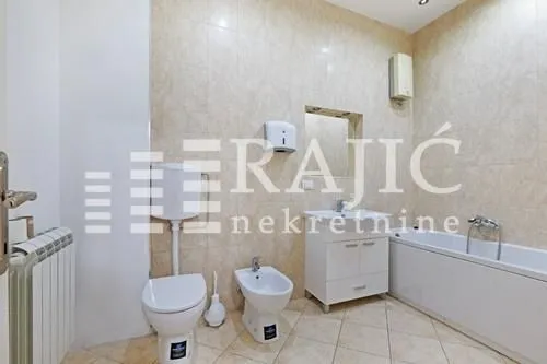 Fully equipped bathroom with a bathtub, washbasin, and sanitary fixtures.
