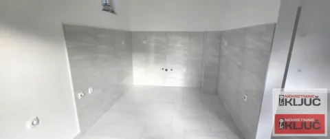 Unused kitchen with light wall and floor tiles. - image 8