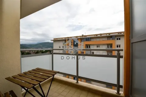 Covered balcony with a wooden table and a view of the neighborhood. - image 10