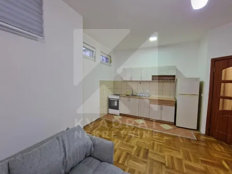 Dnevna soba sa kuhinjom i trosjedom u prvom planu. - image 4