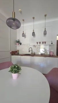 Moderna kuhinja sa trpezarijskim stolom i visilicama. - image 4