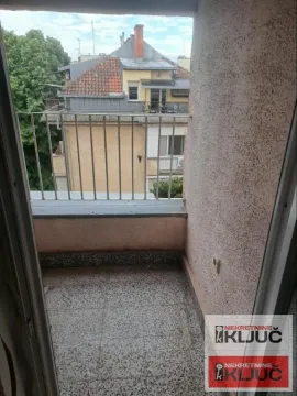 Manji balkon sa metalnom ogradom i pogledom na okolne zgrade. - image 6