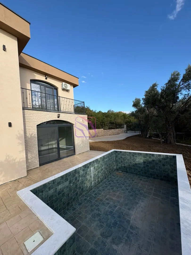 Exterior of the house with a swimming pool and landscaped yard.