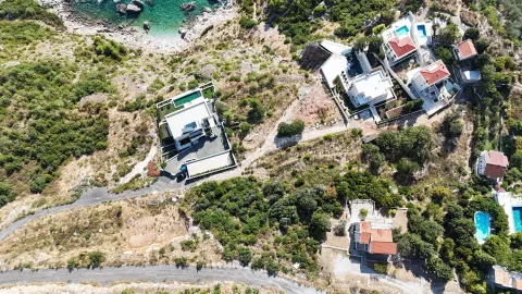 Pogled iz vazduha na kuće smještene u brdovitom priobalnom području. - image 5