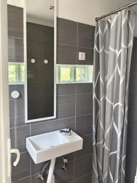 Bathroom with a sink, mirror, and a shower with a curtain. - image 7
