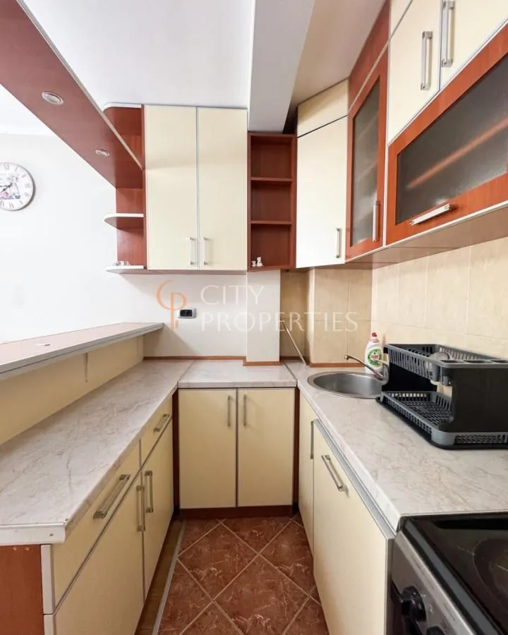 Compact kitchen with wooden cabinetry and countertops.