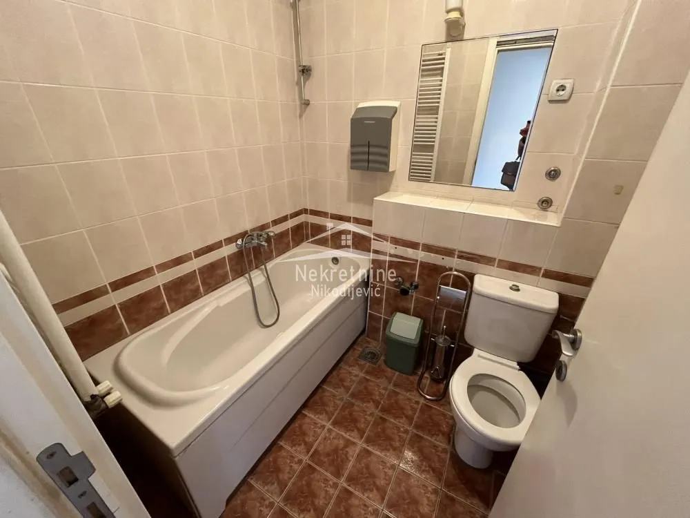 Bathroom equipped with a bathtub, toilet, and sink with a mirror.
